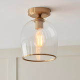 Halstead Flush Ceiling Light in aged brass with clear glass dome shade and exposed E27 bulb, shown fitted to a white ceiling.
