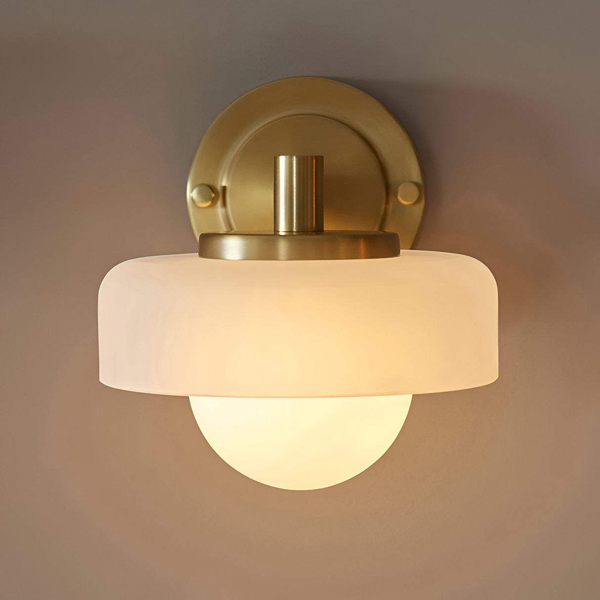 Endon Ashby wall light in brushed aged brass with a frosted glass outer shade layered over a matt opal glass sphere, mounted on a round backplate.