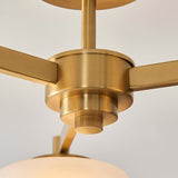 Close-up of the Endon Ashby semi-flush ceiling light's central hub, showing the aged brass finish, ridged finial, and arms extending to glass shades.