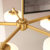 Close-up of the Endon Ashby 5 Light Pendant showing the brushed aged brass hub, radiating arms and opal glass shades against a neutral interior.