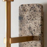 Bramble Wall Light close-up showing the natural stone backplate with brown veining and slim brass-toned arm against a plain white wall.