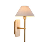 Bramble Wall Light in brass and natural stone, featuring a tapered linen shade on a slim brass arm with a marble backplate, shown on a plain white background.