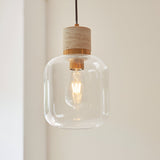 Endon Cranstead pendant light with beige travertine top, brushed brass collar, clear rounded glass shade and warm E27 filament LED bulb.