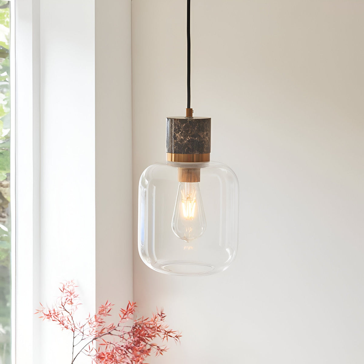Cranstead Pendant Light in brass and brown with marble top, brass collar, and rounded clear glass shade showing an E27 bulb.