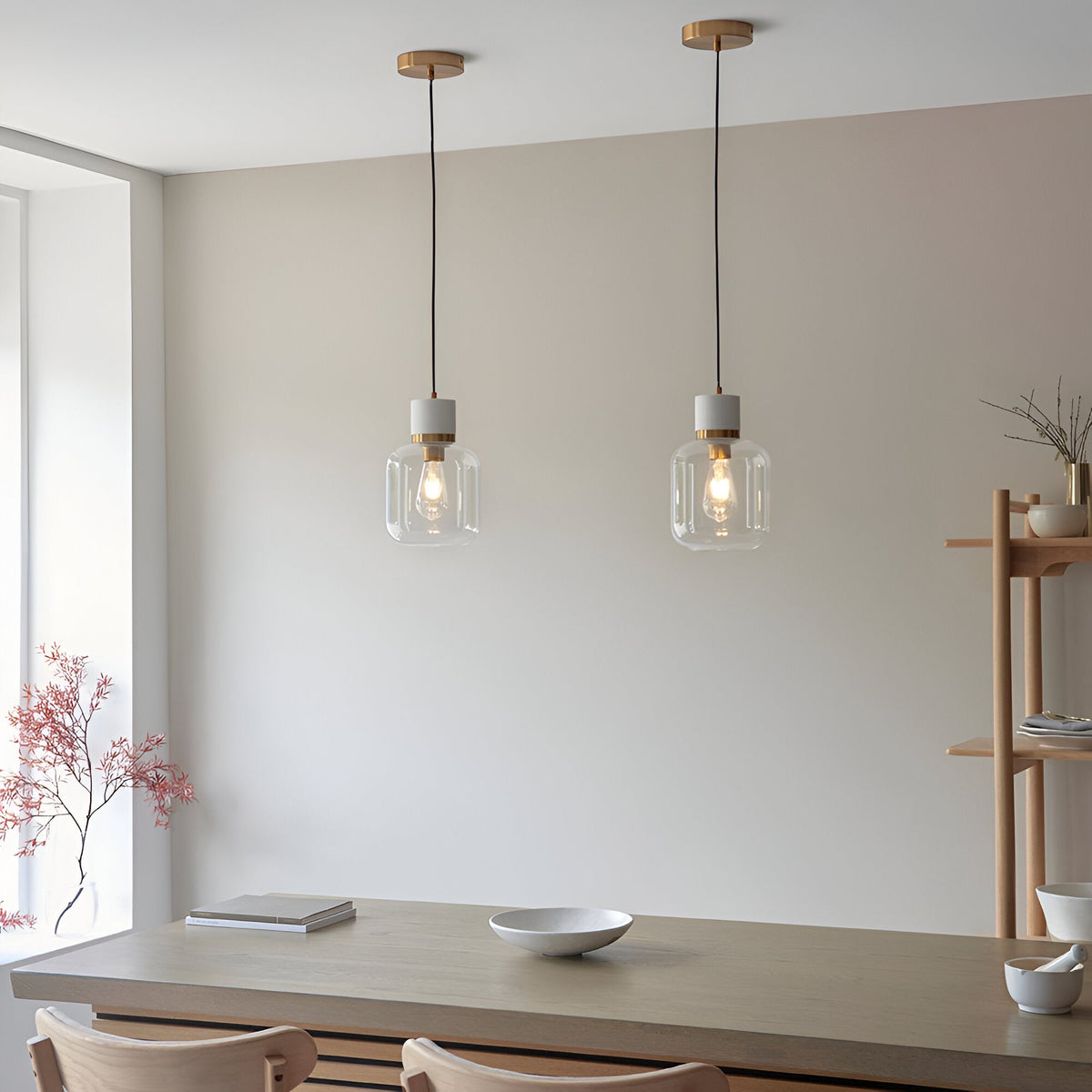 Pair of Endon Cranstead pendant lights with white stone tops, brass collars and clear glass shades hung above a wooden dining table.