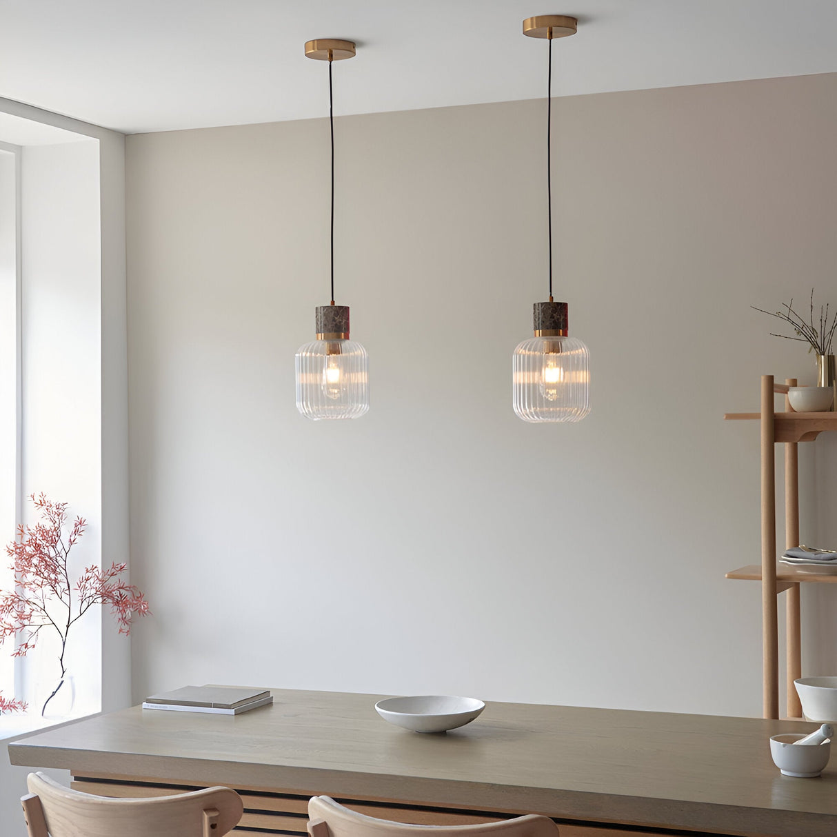 Pair of Endon Cranton pendant lights with ribbed glass shades, brown marble tops and brass fittings, hung above a wooden dining table.