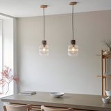 Pair of Endon Cranton pendant lights with ribbed glass shades, brown marble tops and brass fittings, hung above a wooden dining table.