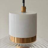 Cranton Pendant Light close-up showing white stone top, brushed brass collar, and ribbed clear glass shade with black cable, on a plain light background.