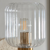 Cranton Wall Light close-up showing ribbed clear glass shade, brass fitting, and warm filament bulb.