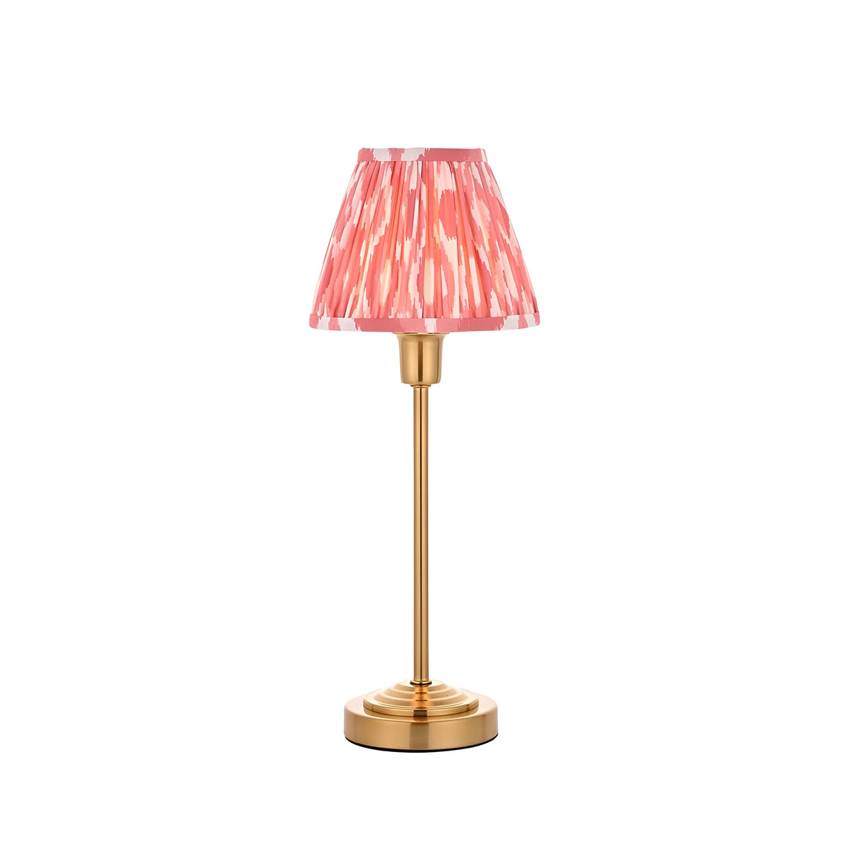 Endon Cliffbourne Ikat table lamp with slim brushed brass stepped base and pleated pink ikat-print faux silk tapered shade, on a white background.