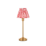 Endon Cliffbourne Ikat table lamp with slim brushed brass stem and stepped base, topped by a pleated coral pink ikat-print tapered shade, on white.