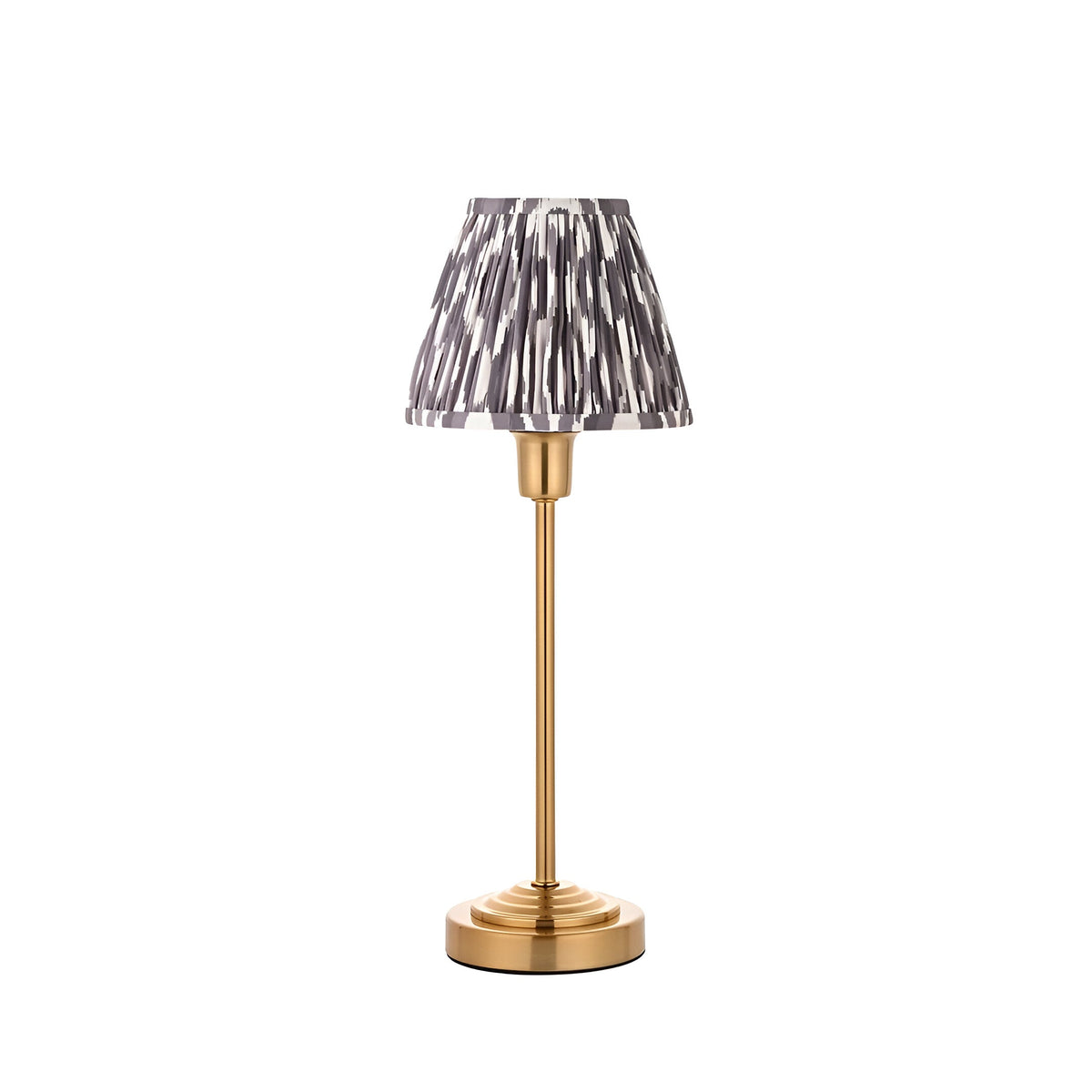 Cliffbourne Ikat Table Lamp with brass stepped base and pleated grey-and-white patterned fabric shade, shown on a plain white background.