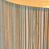 Close-up of the Salcombe Table Lamp's woven seagrass drum shade in natural tones, showing the textured weave and warm glow from within.