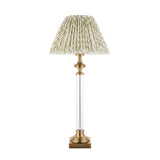Endon Aldmont Leaf table lamp with clear glass column, antique brass base and cap, and pleated green leaf-print faux linen shade on a white background.