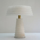 Orivon 3 Light Sculpted Alabaster Table Lamp in soft white, with ribbed tapered base, banded drum shade and brass finial, shown against a plain light background.