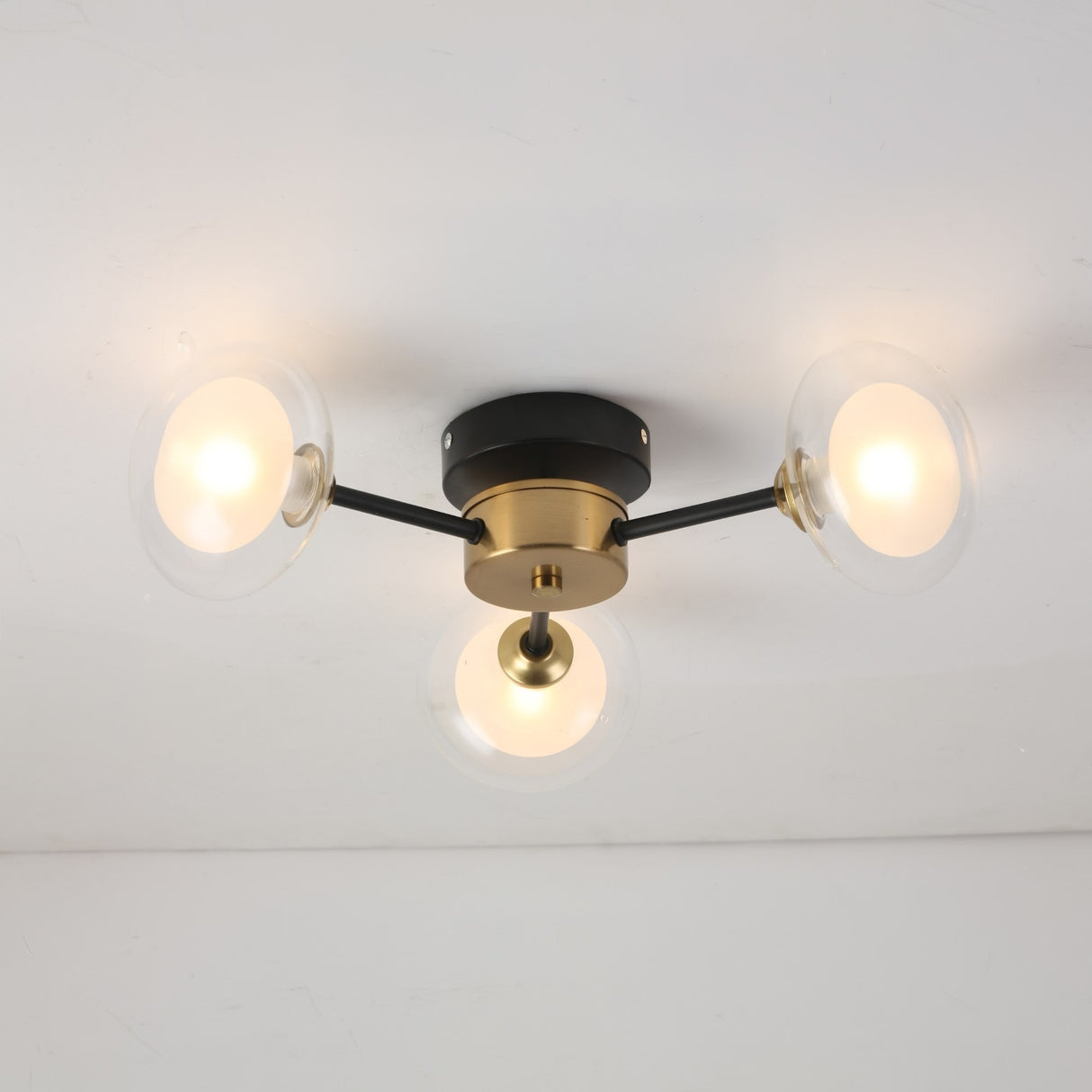 The Galaxy 3 Light Wall/Semi-Flush Ceiling Light - Black & White is a modern, retro-inspired fixture with three frosted glass bulbs on a striking black and white base, perfect for stylish ceiling or wall lighting.