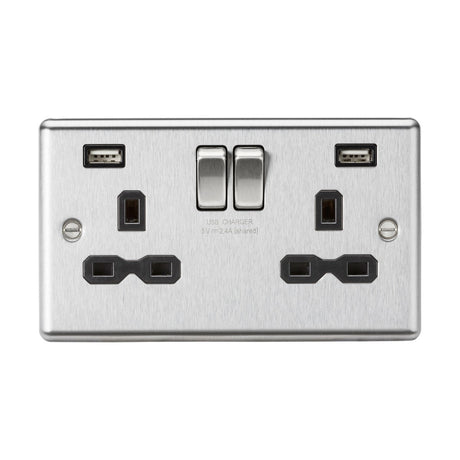 The 13A 2 Gang SP Switched Socket With Dual USB in brushed chrome, featuring a black insert and rounded edge, offers two standard three-pin plug outlets alongside a dual USB charger. It includes individual switches for each outlet, blending modern design with functionality to enhance both efficiency and style.