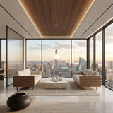 A modern, minimalist living room with wooden and beige furniture, a low marble coffee table, and floor-to-ceiling windows framing a sunset city skyline, illuminated by the gold Pallo Pendant Light with an opal glass diffuser.