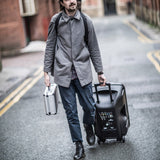 Man walking down a street carrying the AVSL Chord MFC330 aluminium microphone flight case with diamond-patterned silver finish and top handle.