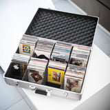 Citronic CDA:120 aluminium CD flight case open on a white surface, filled with CDs held upright by internal separators under a foam-lined lid.