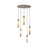 The Orluna 3 Light LED Alabaster Cluster Pendant Light in Chrome & Soft White features three elongated Spanish alabaster lamps suspended at different heights from a round metallic plate, offering an elegant, warm glow.