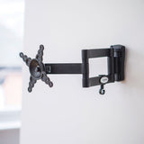 AV:Link HQT201 full motion double arm TV wall bracket in black steel, mounted on a white wall with arms extended and VESA plate visible.