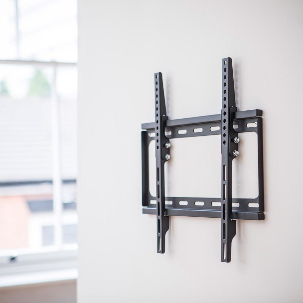 AV:Link ST401 tilting TV wall bracket in matte black steel on a white wall, showing the low-profile VESA 400x400 frame with vertical arms and fixing bolts.