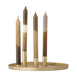 Maxime Iron Christmas Candle Holders set in gold, round textured tray holding four slim brass tube holders with tapered candles in brown, beige, and grey shades, shown on a white background.