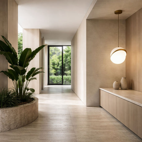 A modern hallway with light wood walls and floors, a large potted plant, a built-in bench with decorative vases, the Arc Pendant Light - Gold & White overhead, and floor-to-ceiling windows framing green trees outside.