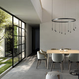 Skybell Circle Iron Ring LED Pendant Light in Ebony Black, a circular fixture with cone-shaped heads on slim stems, shown above a dining table in a modern living space.