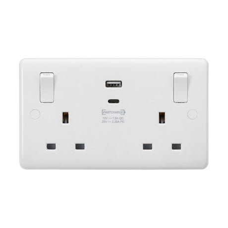 Introducing the 13A 2 Gang SP Switched Socket With Dual USB With Outboard Rockers (Rounded Edge), a stylish white dual electrical wall socket. It features a sleek design with a 7mm plate and a fast-charge USB-C port centrally located, alongside two standard plug outlets. Each outlet is equipped with an easy-to-reach switch positioned above, ensuring both style and functionality in one compact unit.