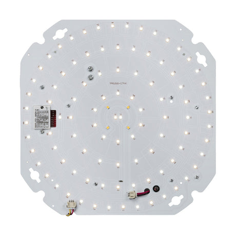 The TENAX10-20W CCT Self-Test Emergency LED Gear Tray With Sensor is a circular board housing color-adjustable LEDs in concentric circles, mounted on a square white base with rounded edges. It comes equipped with gear trays, connectors, and a small electronic component.