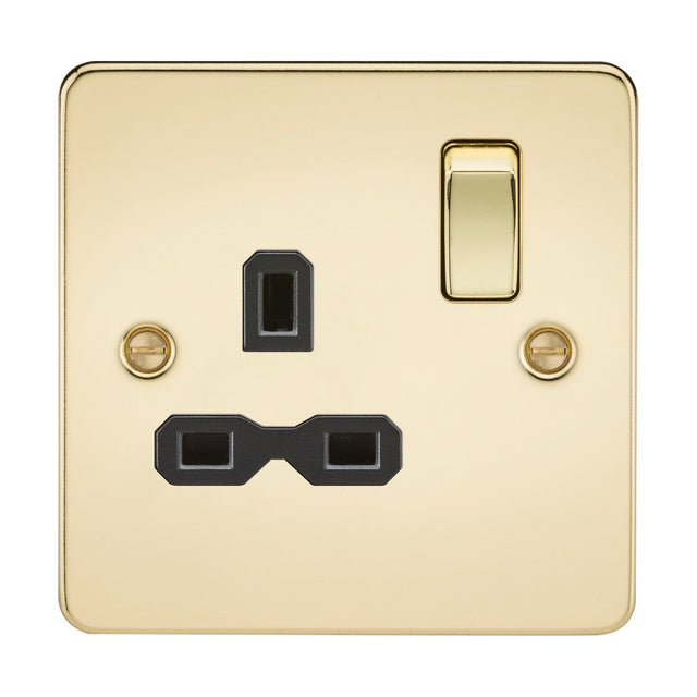 The 13A 1 Gang DP Switched Socket in polished brass finish, known for its square gold-colored design and ultra-low profile aesthetics, includes two black rectangular plug inputs, a switch with a gold toggle, and two visible screws on either side.