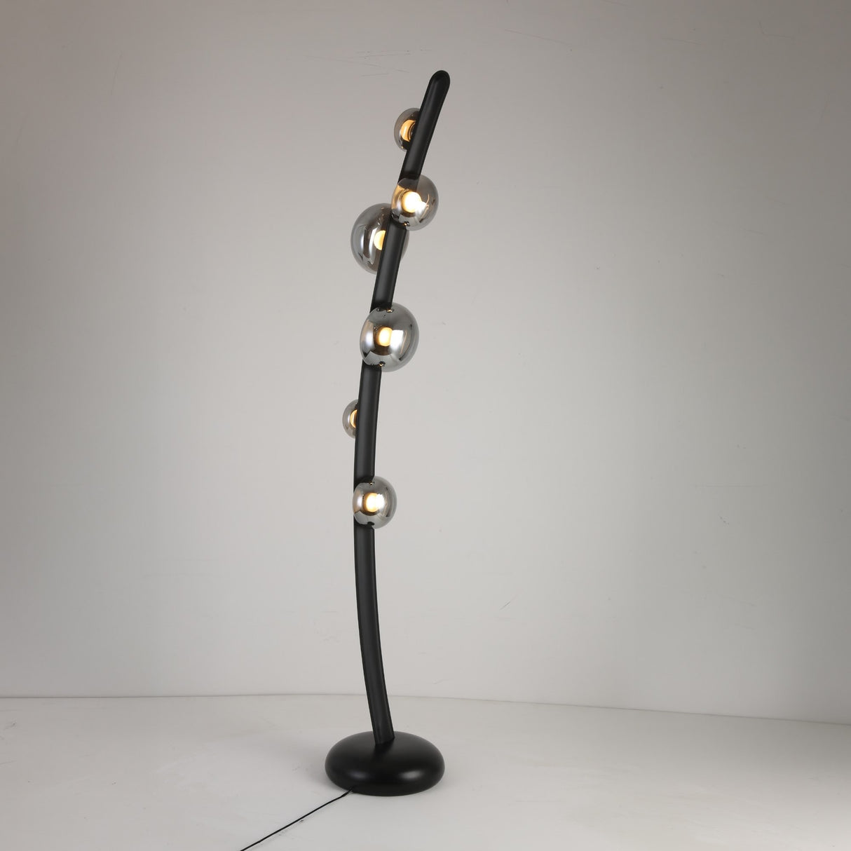 The Cordaro 6 Light Leather Floor Lamp in Black features six spherical bulbs with metallic finishes on a curved black stand and round base, shown against a plain white background.