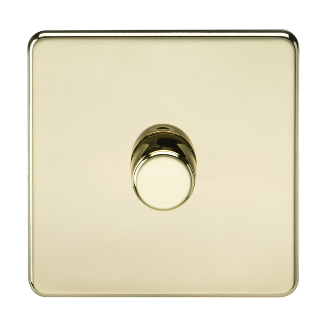 A 1 Gang 2-Way Intelligent Dimmer in polished brass with a screwless design features a square shape and a reflective surface, complemented by a circular knob to adjust light brightness. This elegant dimmer seamlessly integrates into any decor, set against a white background.