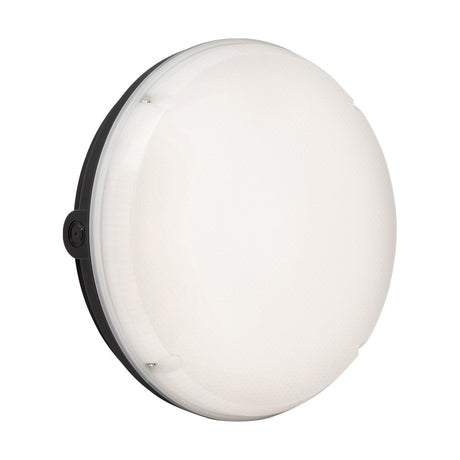 Viewed from an angle, the TENAX One Round Bulkhead Casing - Black features a round, white LED ceiling light fixture with a black base and IK10 impact rating. The smoothly lit surface is ideal for indoor use.