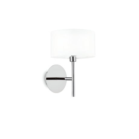 The Noble Light Wall Light - White includes a chromed metal frame with a glossy chrome finish. It stylishly complements a cylindrical white diffuser, all elegantly mounted on a round base, adding a modern flair.