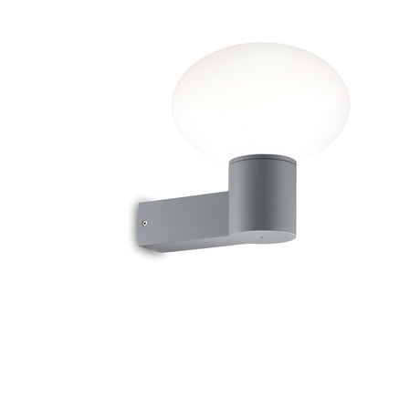 The Photonix Wall Light - Grey boasts a sleek, cylindrical gray base paired with a smooth, white dome-shaped lampshade. Its minimalist design and modern appeal make it perfect for both indoor and outdoor use, set against a plain white background to accentuate its contemporary feel.