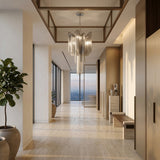 A modern, elegant hallway with large windows offering a city view, beige marble floors, the Valora 5 Light Metal Chain Veil Chandelier - Nickel, potted plants, and minimalist wooden furniture against light-colored walls.