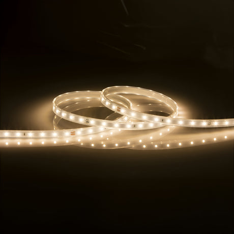 The 24V LED Strip Light IP67 3000K - 30m softly illuminates against a dark background. Its warm white light emits a gentle glow, accentuating the curves and loops of the strip, driven by a constant voltage driver for consistent illumination.