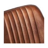 Close-up of the Angelo bar stool's vertical channel-stitched brown leather backrest, showing the tan-to-dark patina and stitched seams on a curved top edge.
