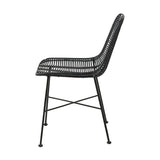 Side view of the Black Rattan Core & Iron Dining Chair, showing a woven black rattan seat and curved backrest on slim black iron legs with cross-brace support, set against a plain white background.