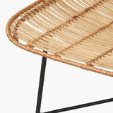 Close-up of a Rattan Core & Black Iron Dining Chair showing the woven natural rattan seat detail and angled black metal legs on a plain white background.