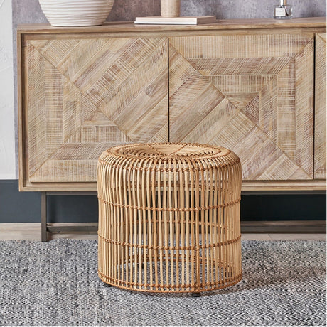 Rattan Core Stool in natural finish, round woven design with vertical cane detailing, shown beside a wood-panelled sideboard on a patterned rug.