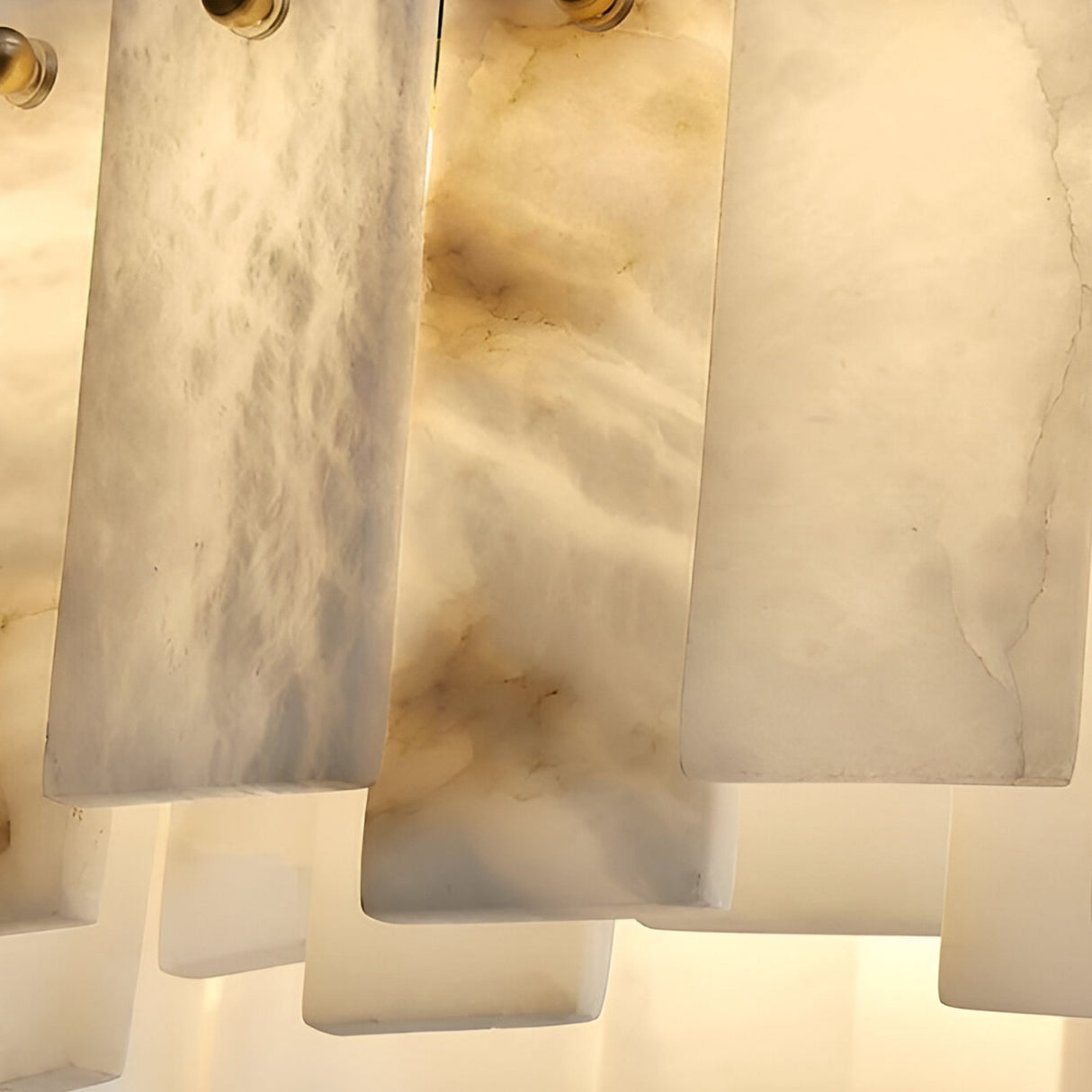 Close-up of softly veined, translucent panels on the Valeris 14 Light Layard Panel Alabaster Linear Chandelier in Soft White & Brass, arranged vertically and backlit for a warm glow—ideal as layered stone lighting or a statement chandelier.