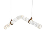Niori Zareon LED Large Chevron chandelier with bent Spanish alabaster tube, brushed brass collars and twin black cables on a white background.