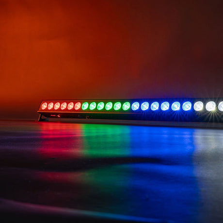Citronic BatBar-100 rechargeable RGBW LED wall bar by AVSL, lit in red, green, blue and white segments against a warm orange backdrop.