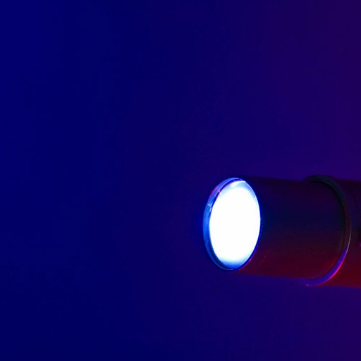 Citronic PAR60-RGB 60W LED profile spotlight by AVSL shown lit with a bright white beam against a deep blue background.