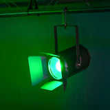 Citronic MFZ160-RGBW mini Fresnel zoom LED stage light with barn doors, rigged on truss and casting a green wash across a dark studio backdrop.