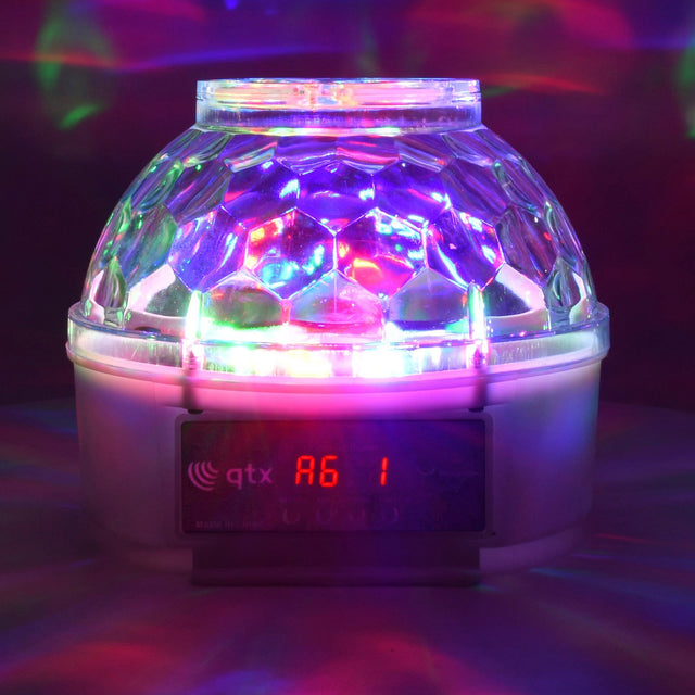 QTX Crystal Blaze RGBW tabletop LED light effect with rippled dome projecting colourful patterns, digital display reading A6 on the white base.